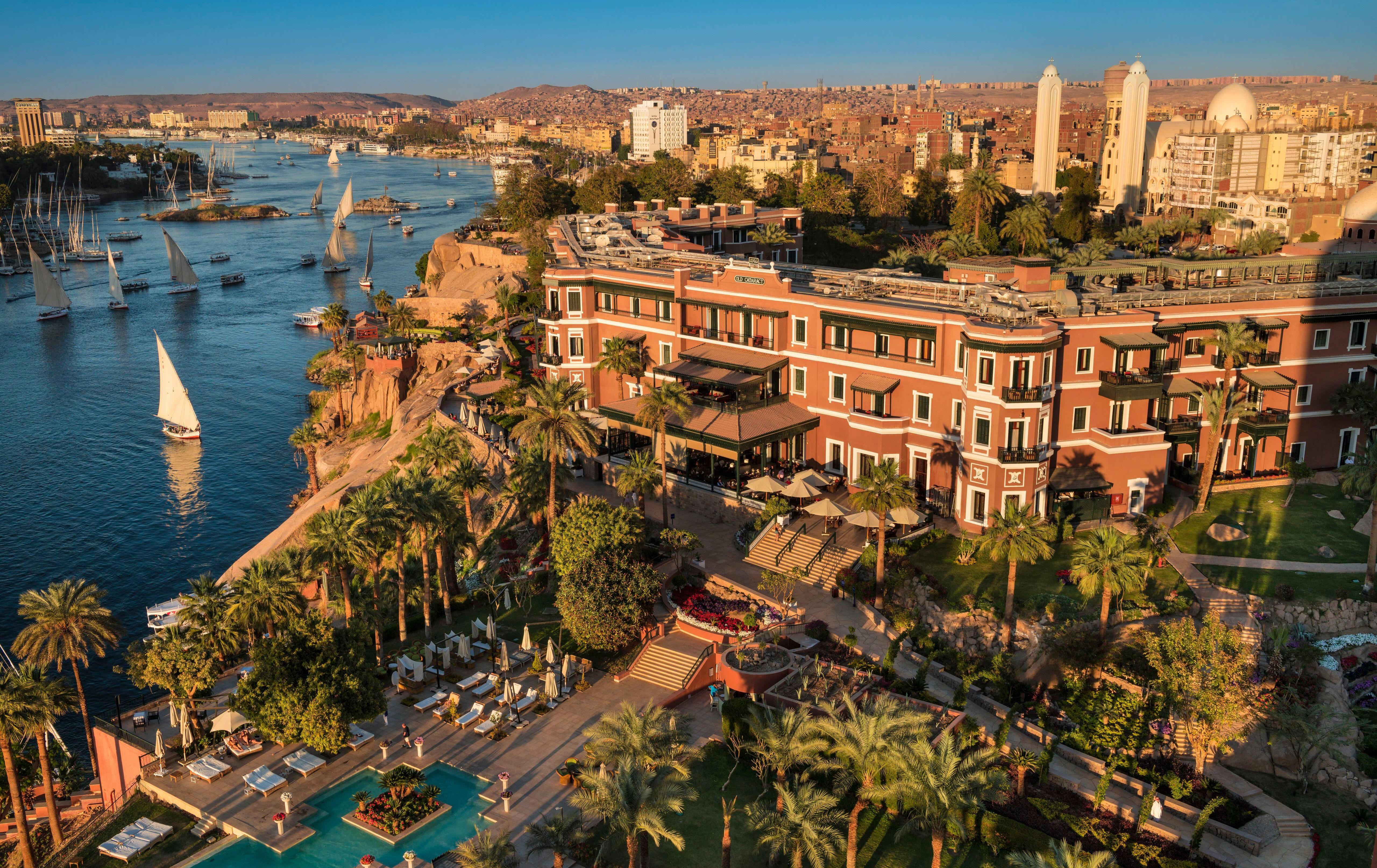 Вид сверху на отель Sofitel Legend Old Cataract в Асване, Египет, с видом на реку Нил и остров Филлот.