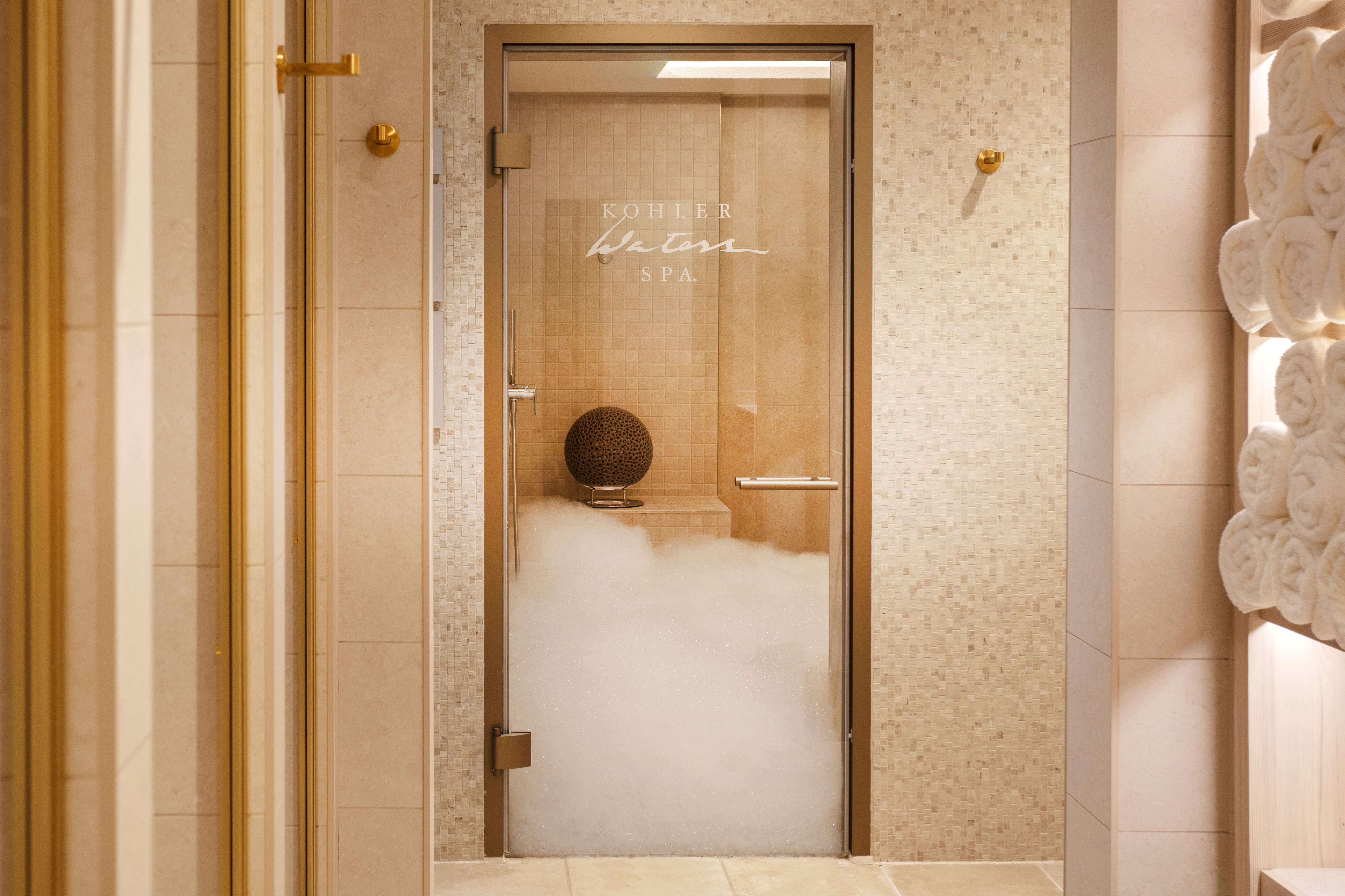 Парная в Kohler Waters Spa с стеклянной дверью.