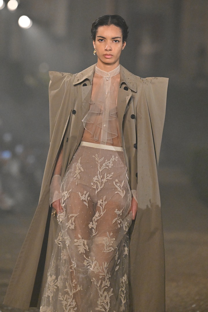 Модель в прозрачном цветочном платье и бежевом тренче на показе мод Dior.