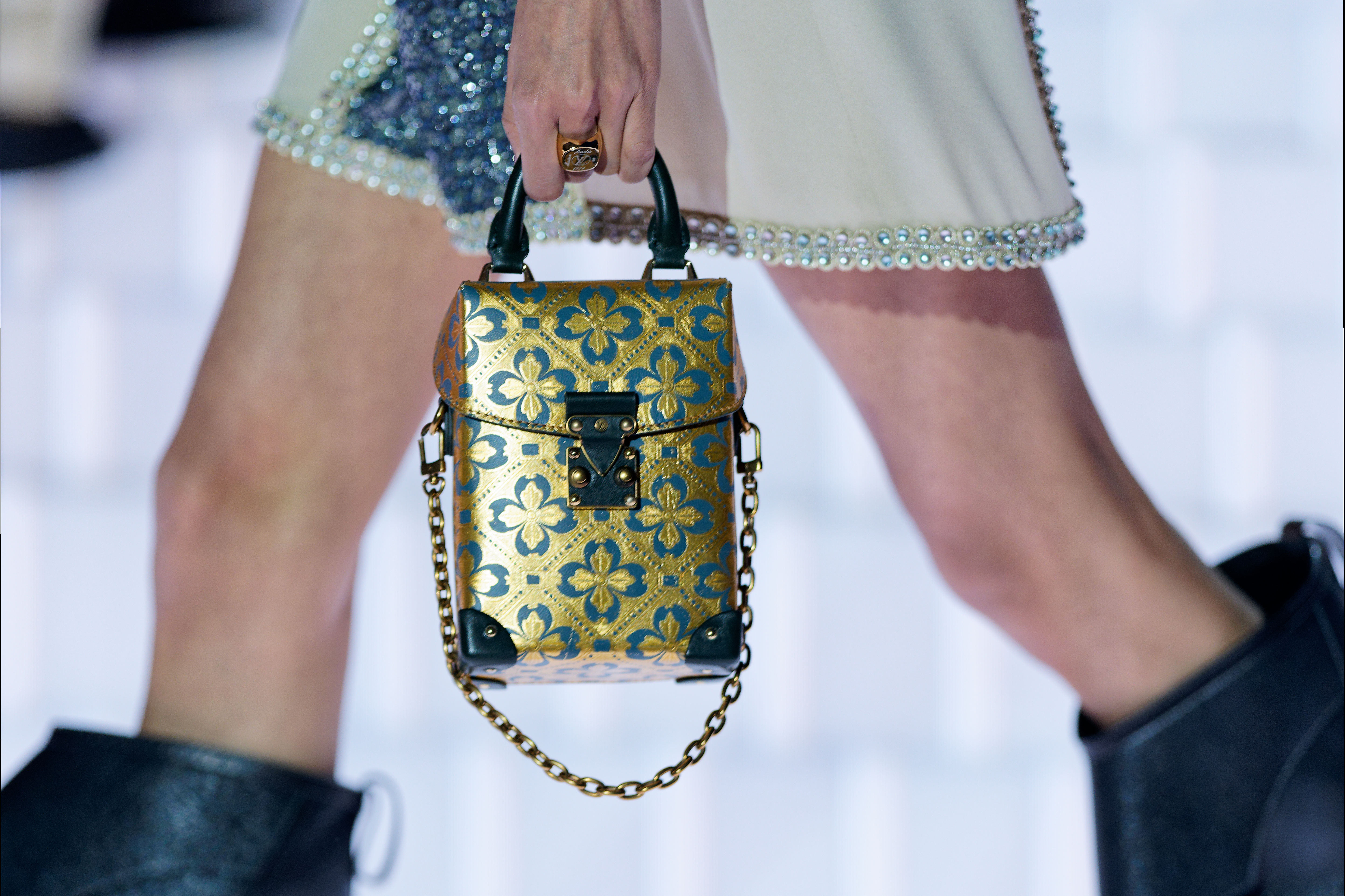 Модель с золотой и синей сумкой Louis Vuitton.