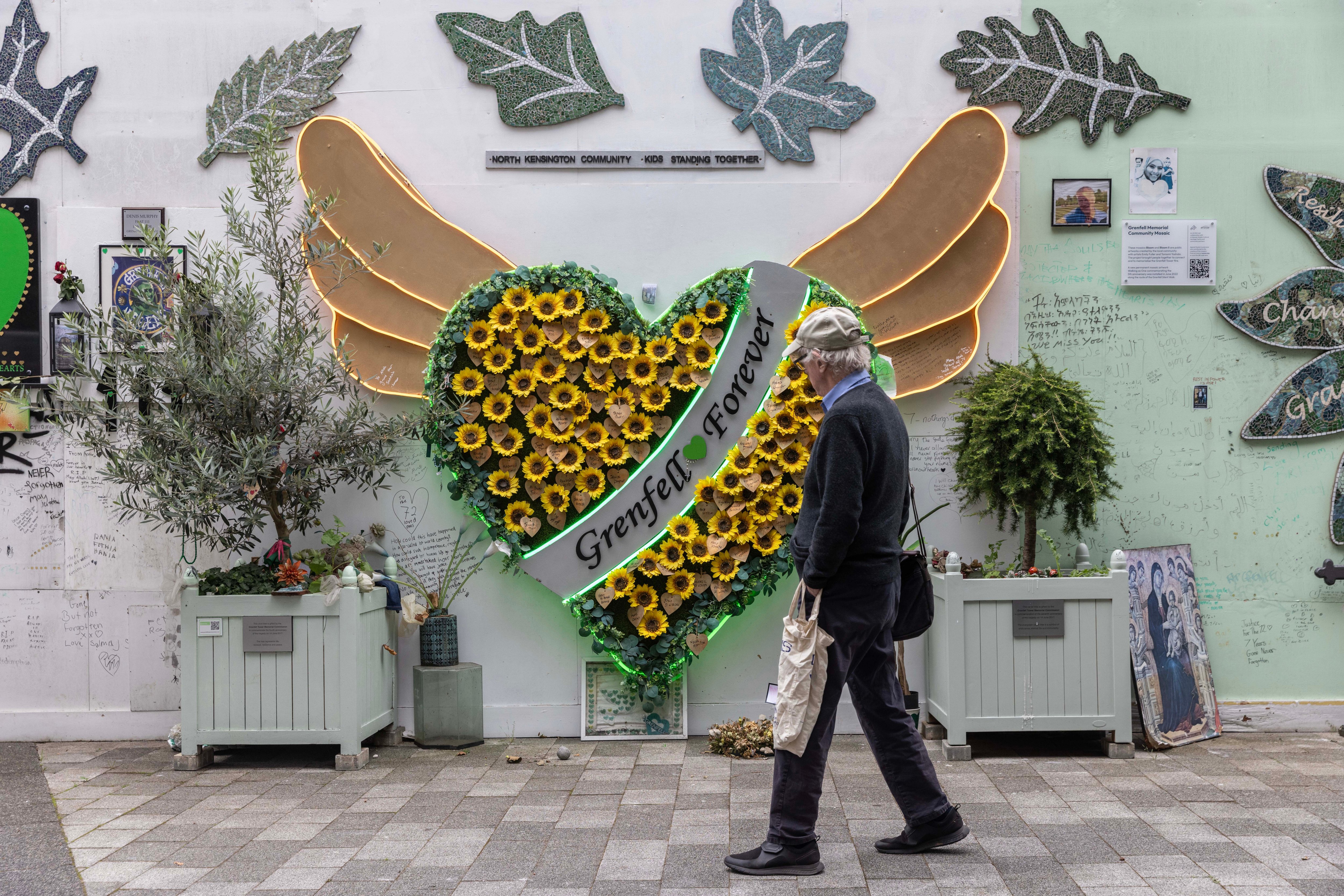 Мемориал башни Гренфелл с подсолнухами и сообщениями.