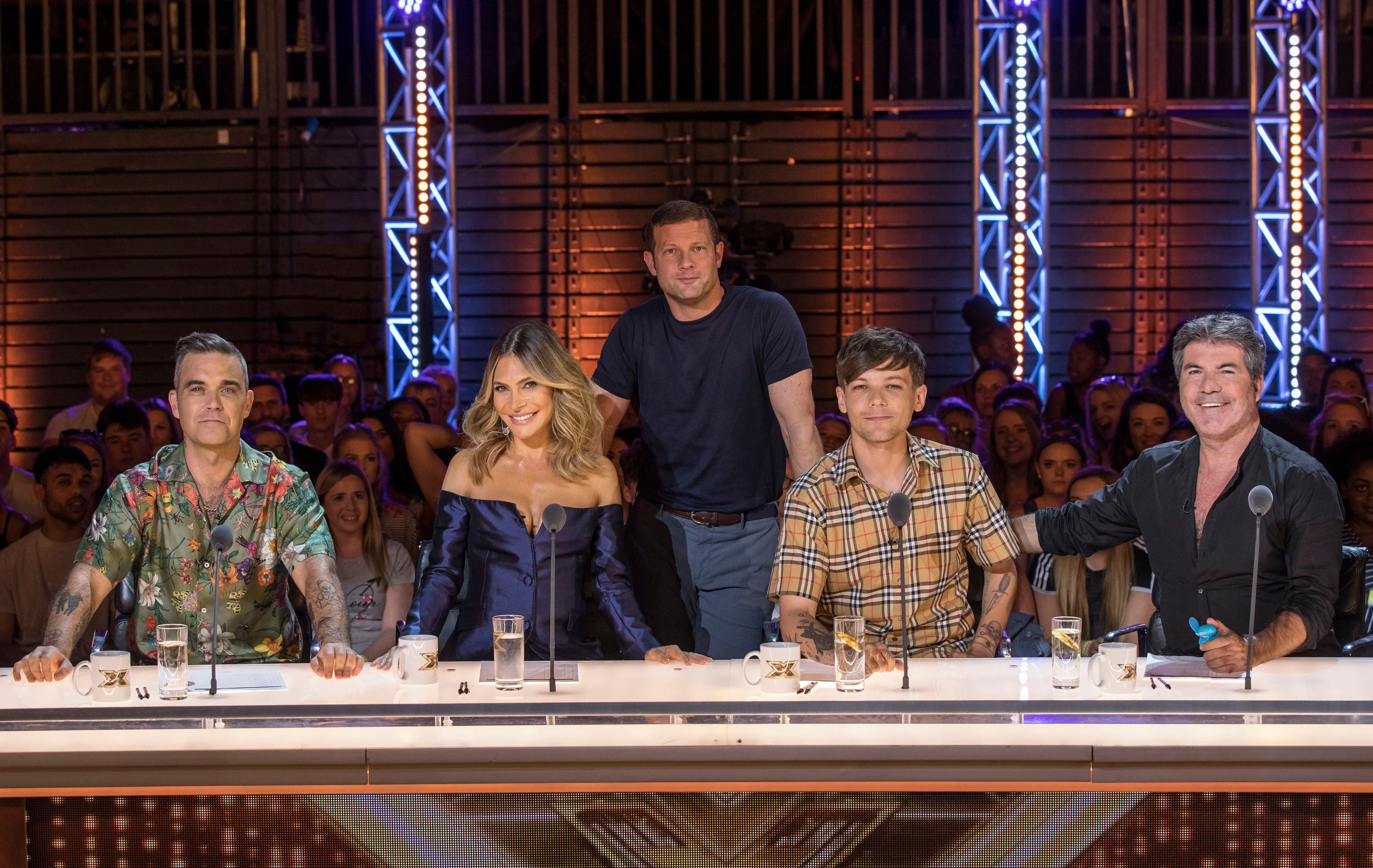 The X Factor judges at the judges' table.