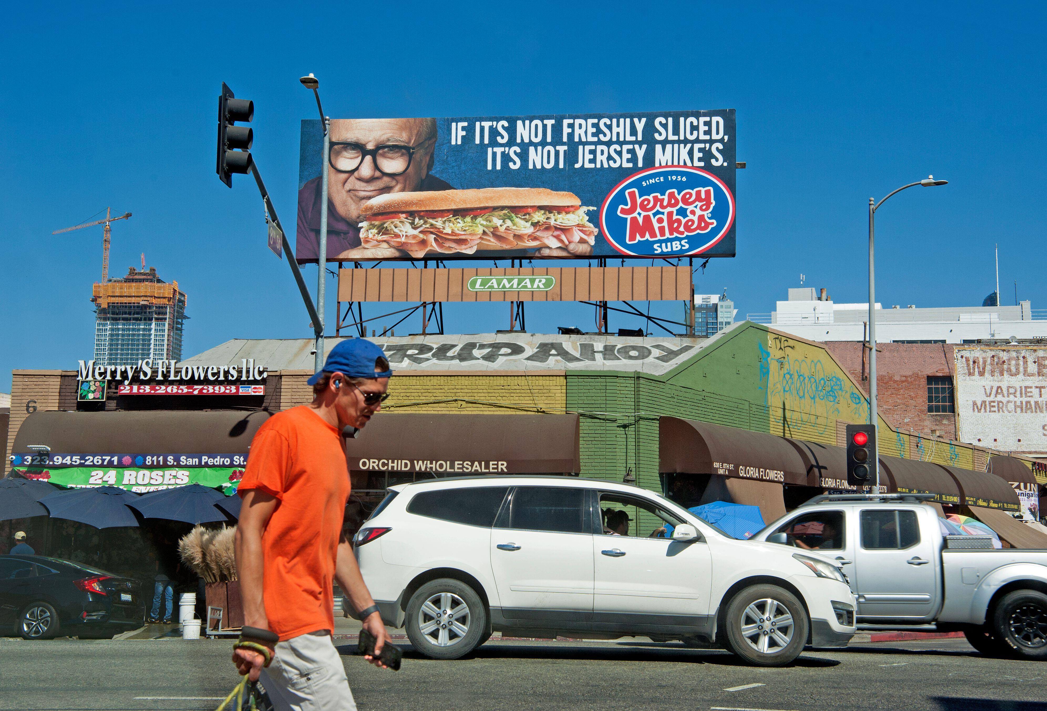 Дэнни ДеВито на рекламном щите Jersey Mike's в центре Лос-Анджелеса.