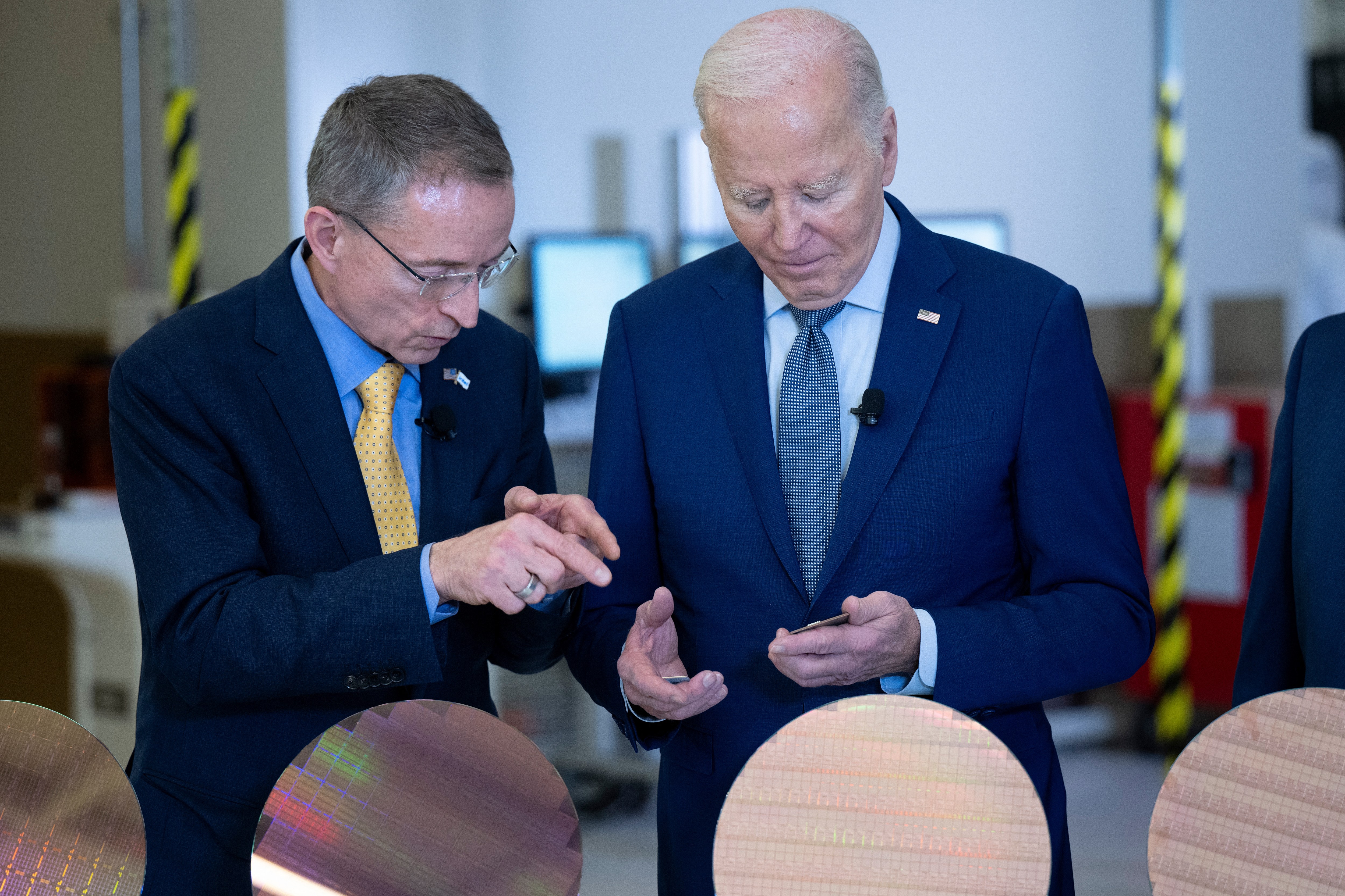 Pat Gelsinger shows President Biden a processor and semiconductor wafer during a visit to Intel in Arizona