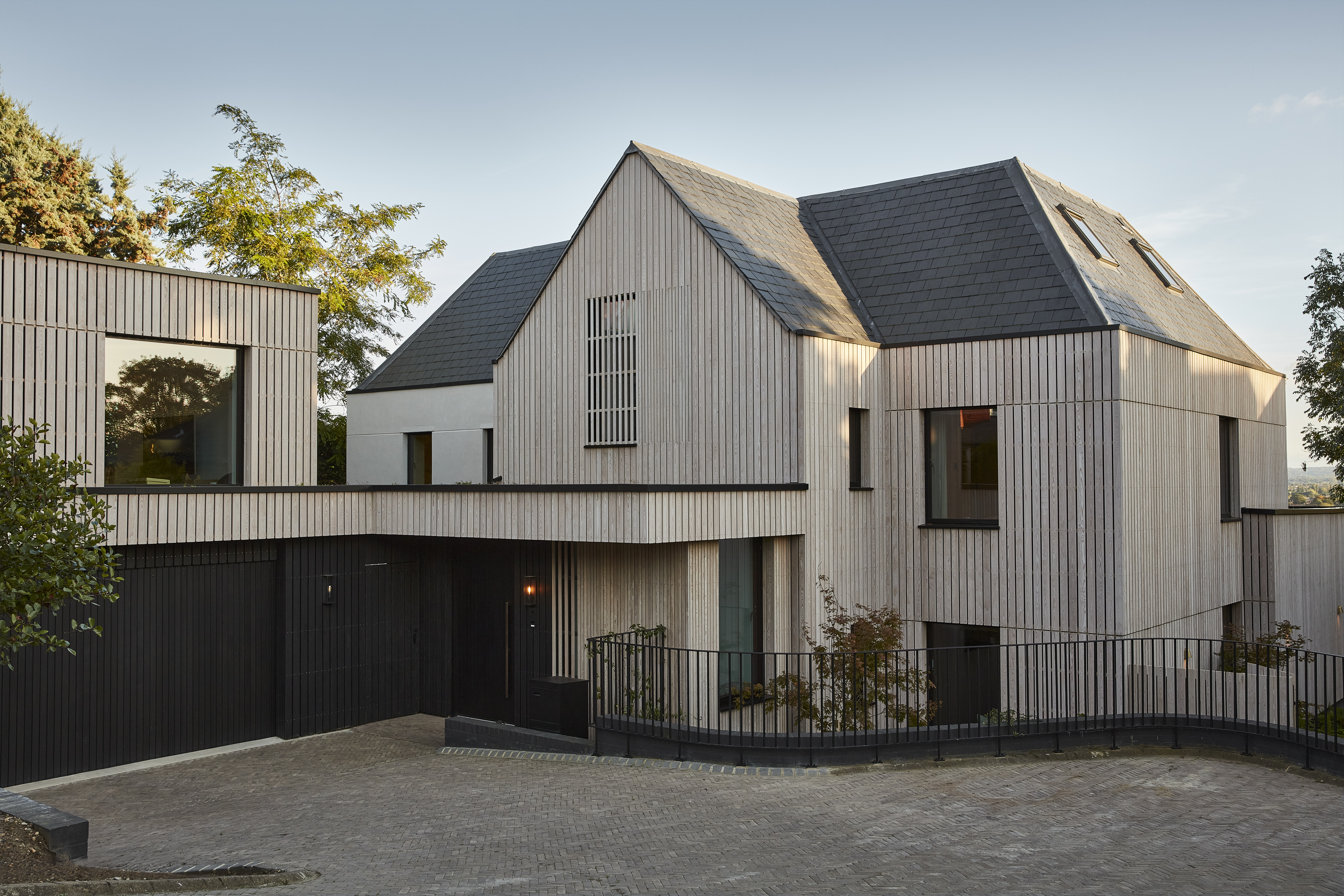 Ретрофитированный дом Passivhaus с деревянной обшивкой и черными акцентами.