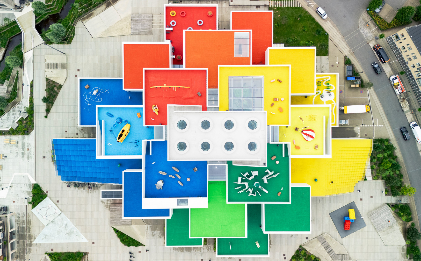 Вид сверху на LEGO House, здание с цветными крышами и игровыми элементами.