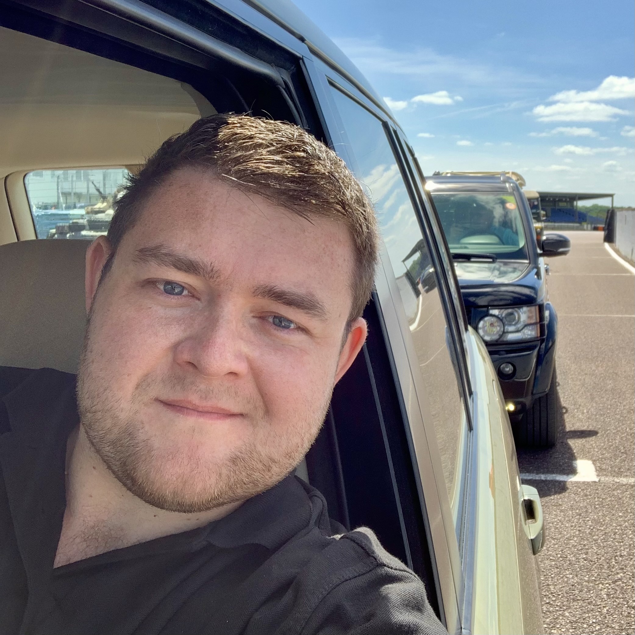 Man in a car, another car visible behind.