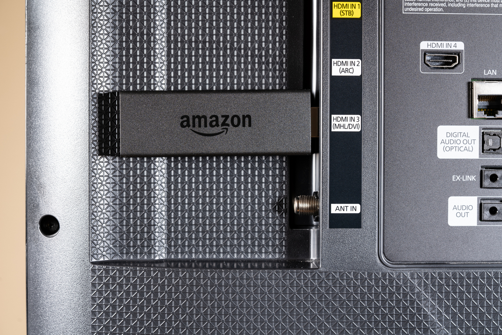 Потоковая палочка Amazon Fire TV, подключенная к HDMI-порту смарт-ТВ.