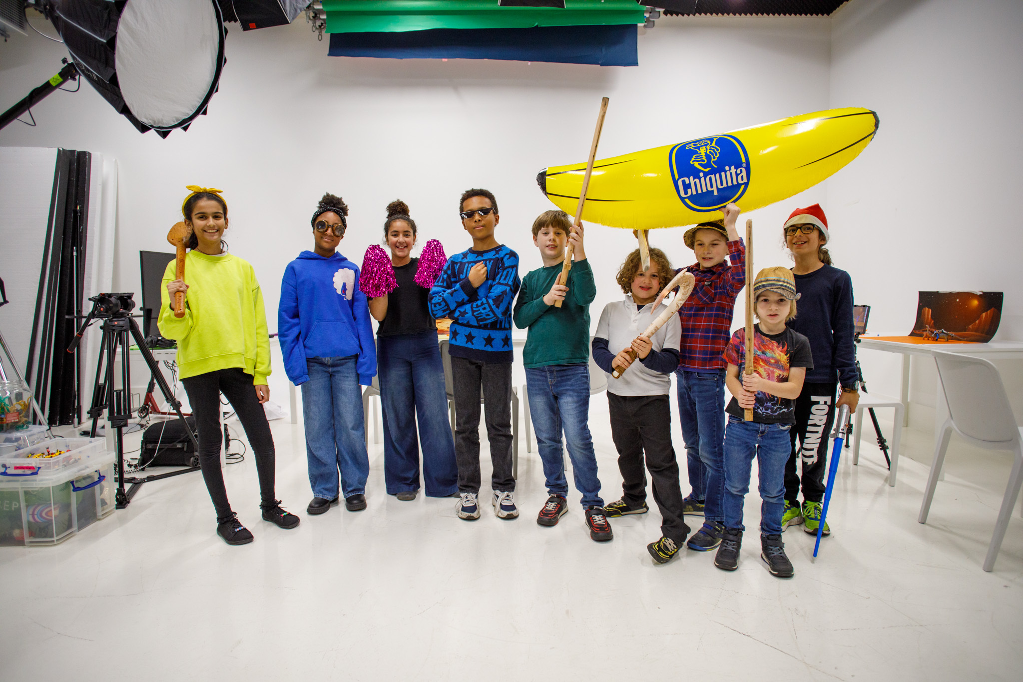 Group of children posing with props in a studio.