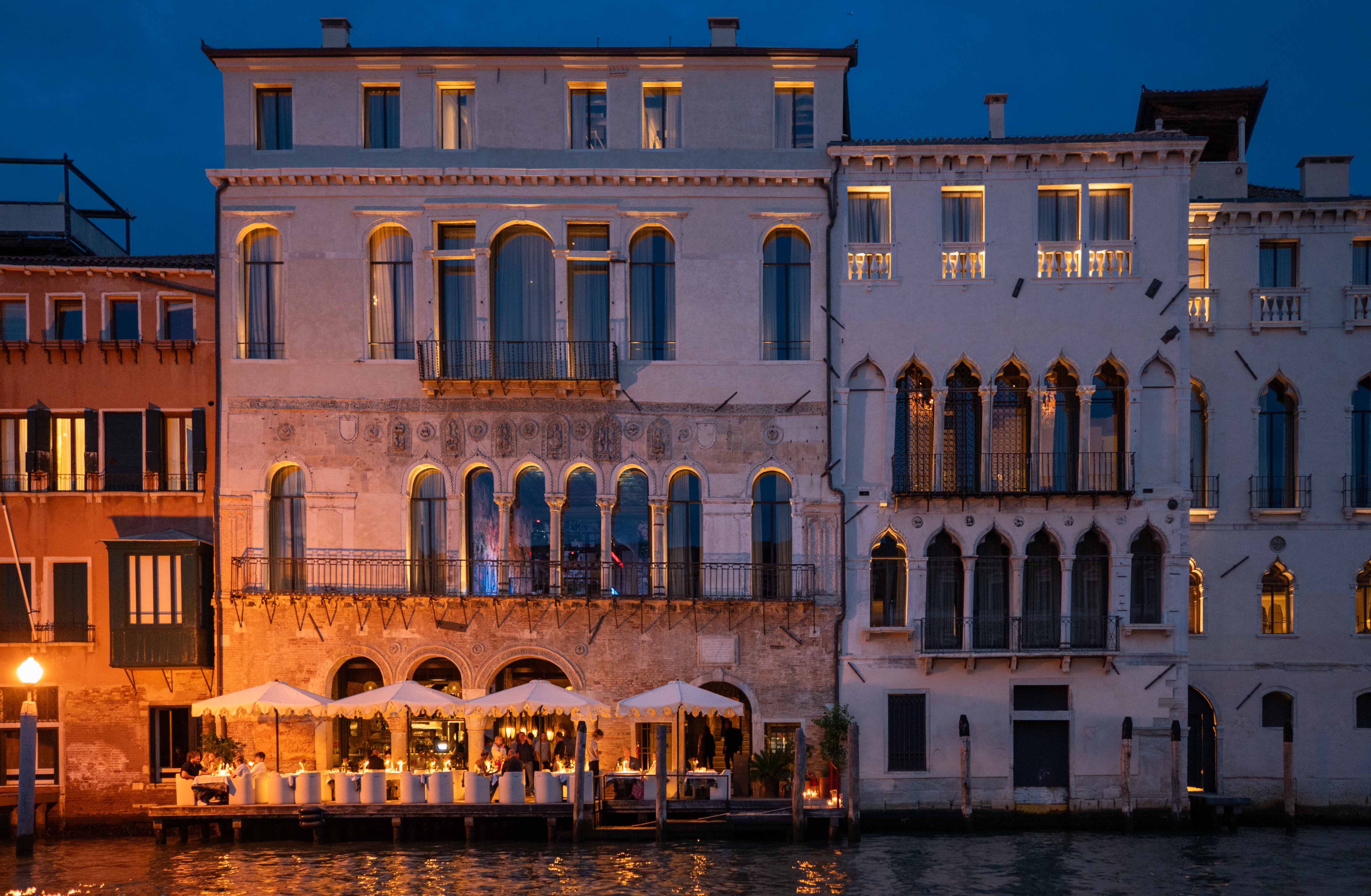 Отель Venice Venice ночью с уличным dining.