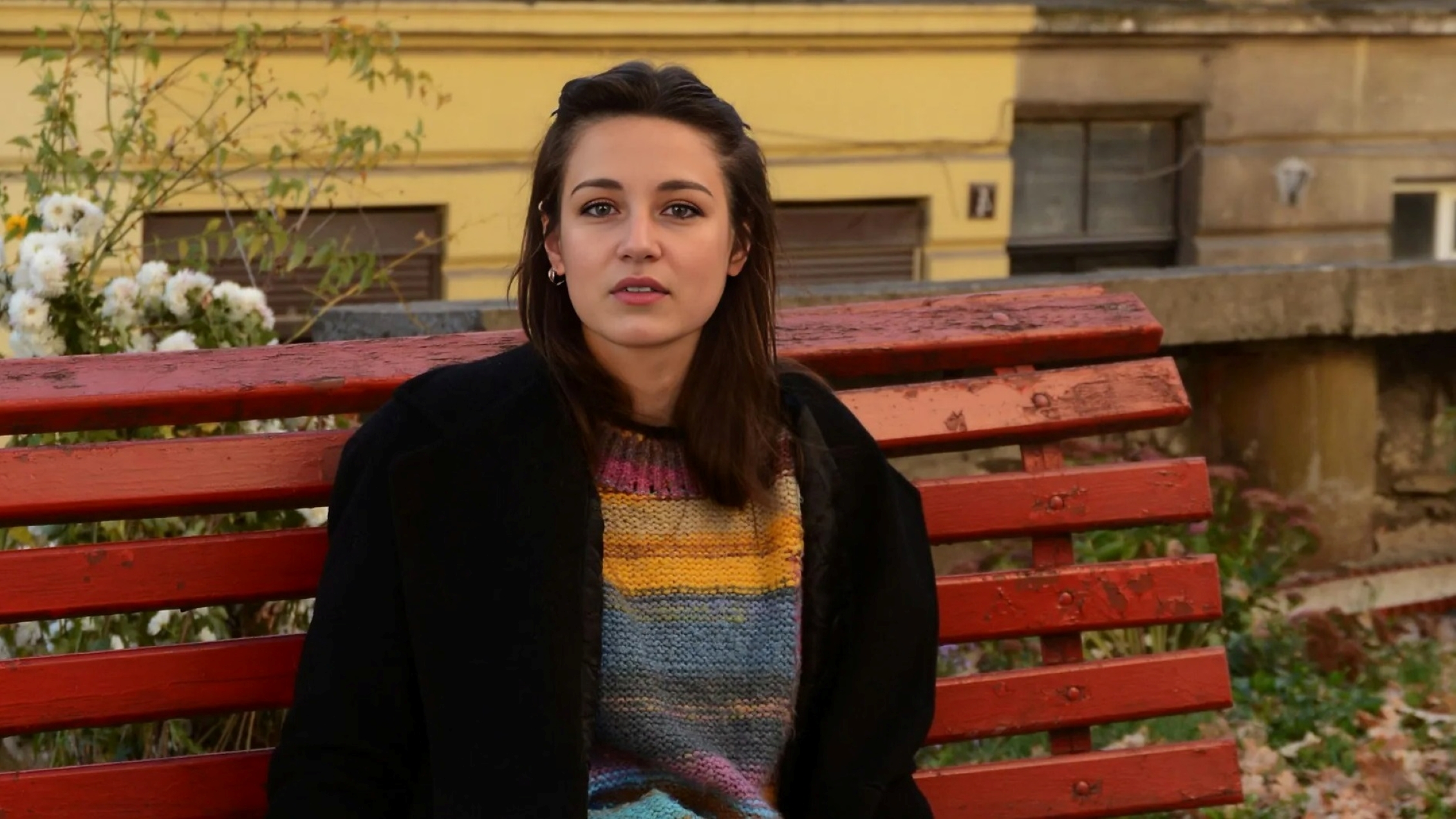 Woman sitting on a red bench.