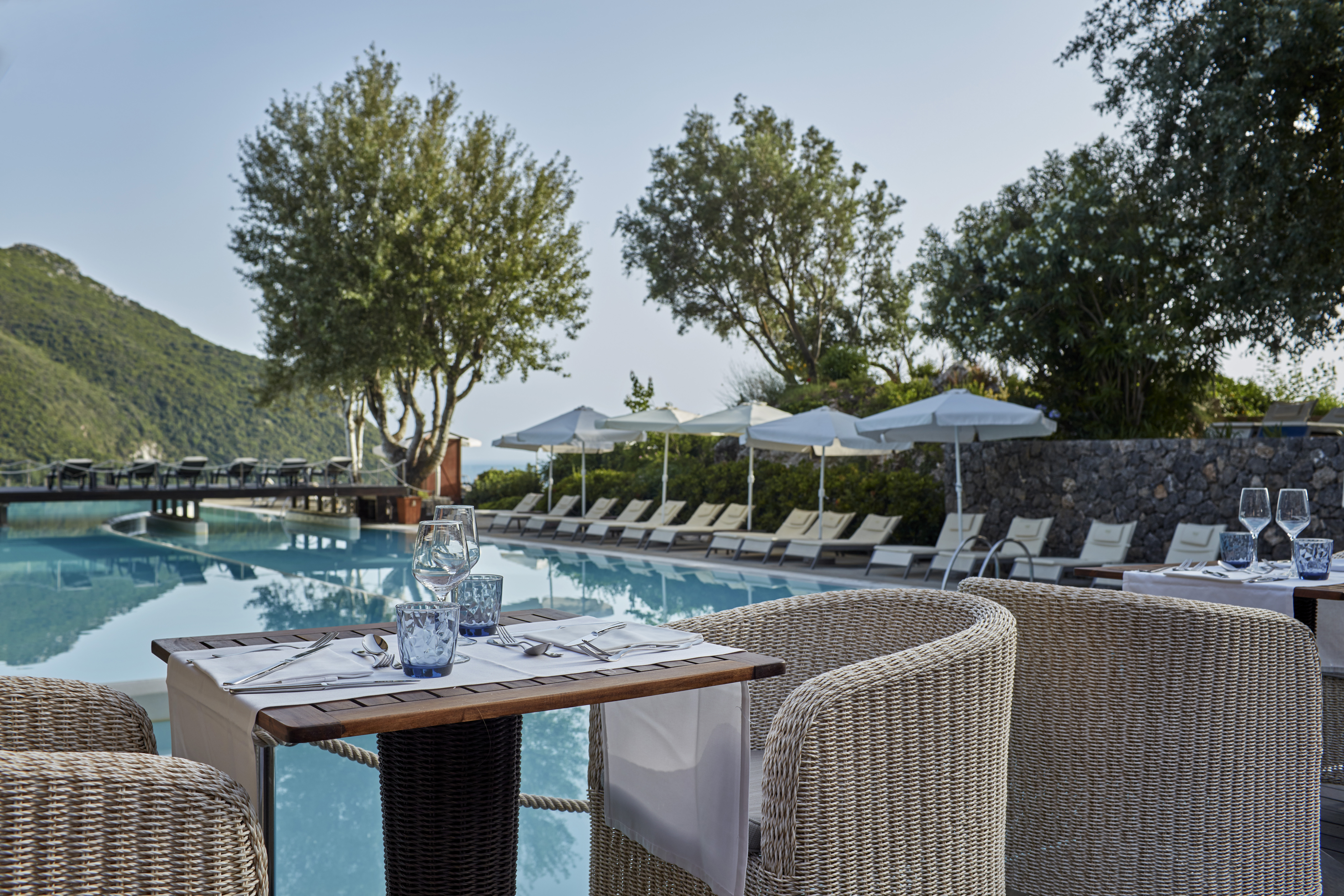 Стол, накрытый для ужина рядом с бассейном в курорте Atlantica Grand Mediterraneo