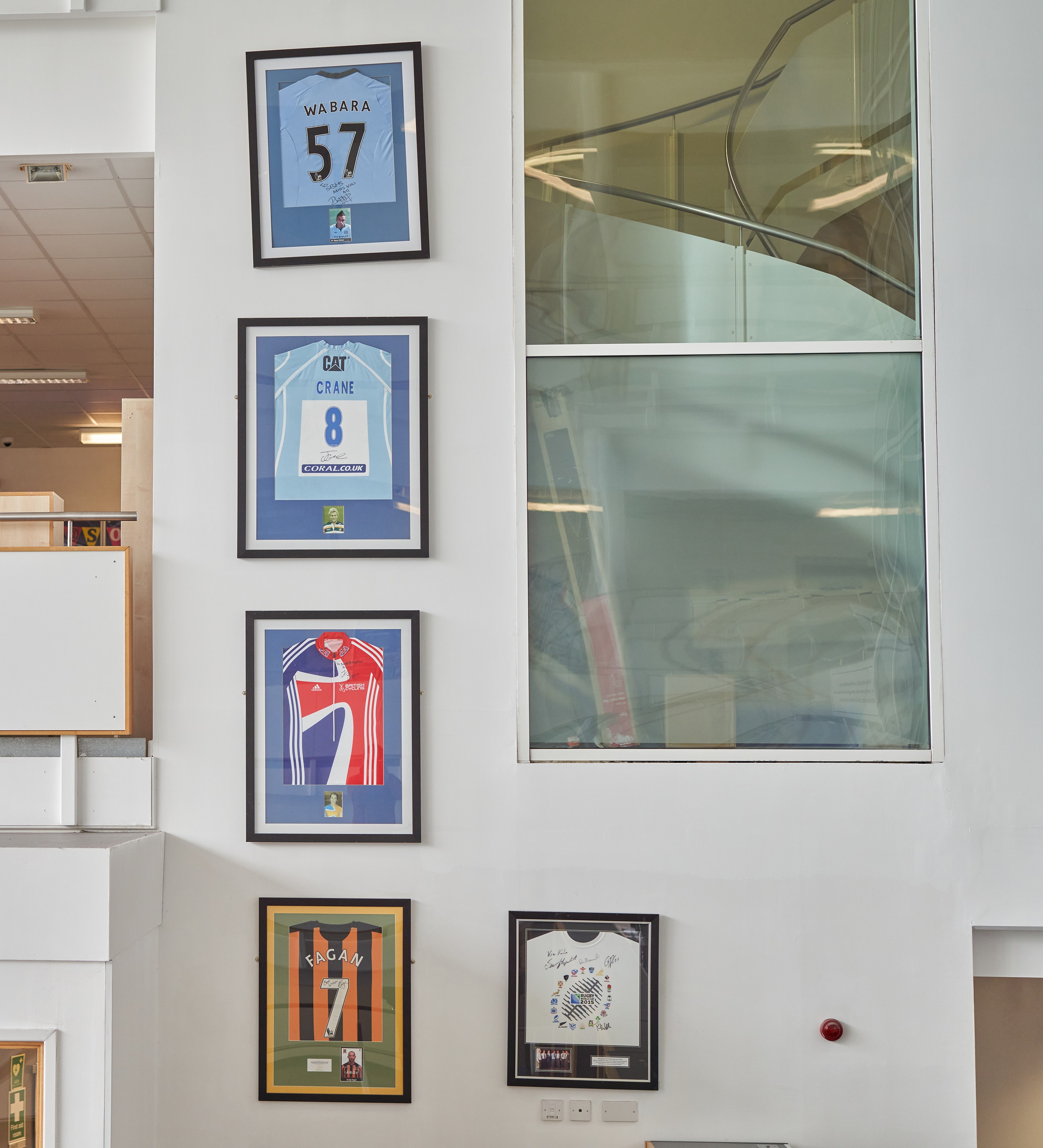 Jess Varnish’s racing bib is displayed prominently in the school’s main foyer, below Wabara’s No 57 Manchester City shirt (top)